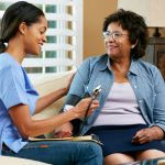 visiting nurse taking blood pressure in a womans home