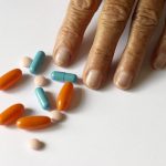 Elderly persons hand by pills