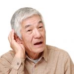 older Japanese man cupping his ear to hear better