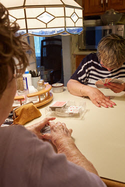 Two women laughing playing cards