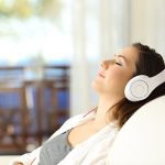 woman relaxing on couch wearing head phones