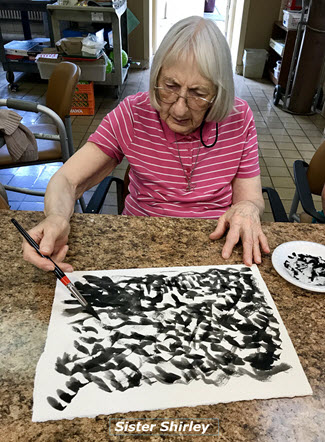 Sister Shirley a woman living with dementia painting the Himalayas