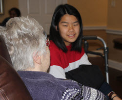 older woman and college student sitting on a coach talking