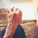 hands of an elderly man using a computer tablet