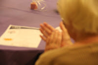 An older woman clapping in time to music