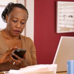 Older black woman with her laptop and phone