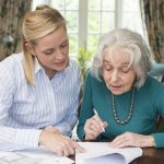 Elder woman going over paperwork with her female lawyer