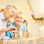 older woman cooking with home health aide